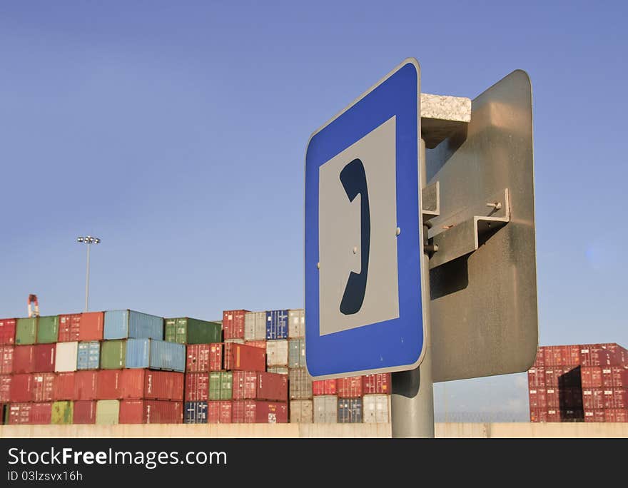 Telephone sign in front of shipping containers at wharf. Telephone sign in front of shipping containers at wharf