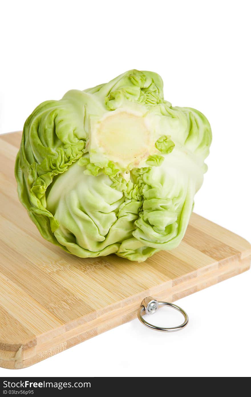 Green cabbage on wooden chopping board isolated on white background