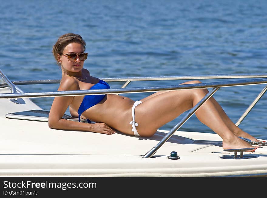 Woman Sunbathing On The Deck Of The Yacht