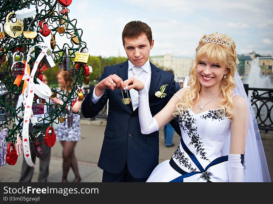 Happy bride and groom at wedding walk on Luzhkov bridge in Moscow. Happy bride and groom at wedding walk on Luzhkov bridge in Moscow