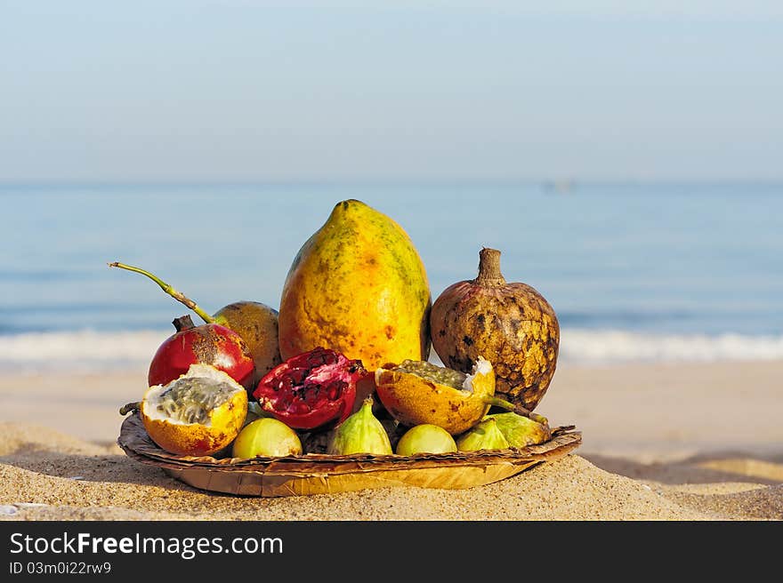 Exotic tropical fruit on the leaves plate, on the sandy beach. Exotic tropical fruit on the leaves plate, on the sandy beach