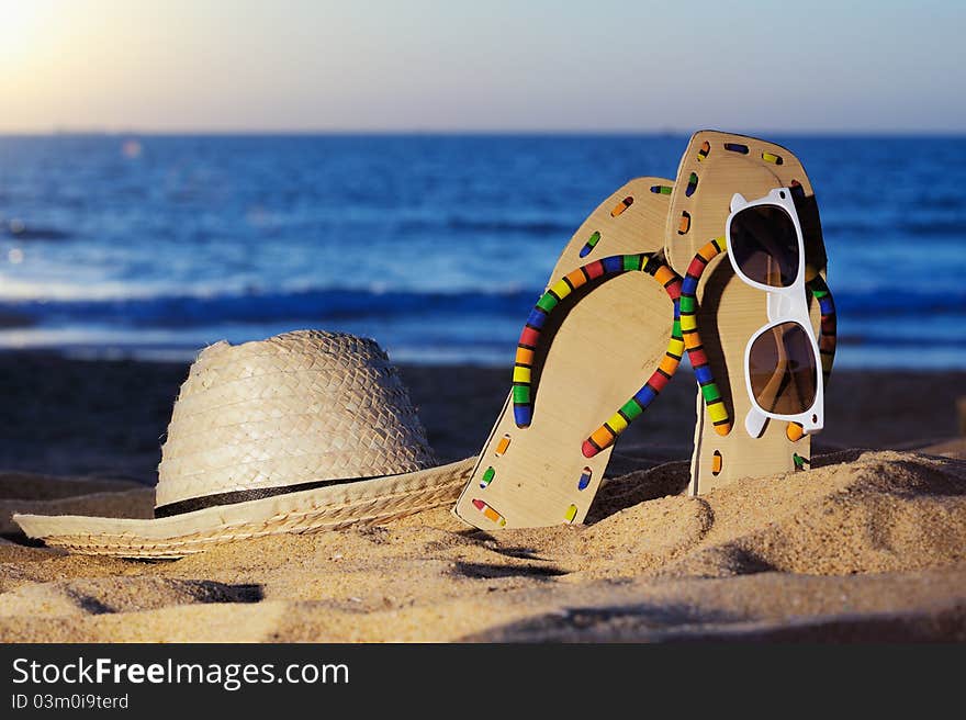 Wicker hat, sandal and glasses on the sandy beach. Wicker hat, sandal and glasses on the sandy beach