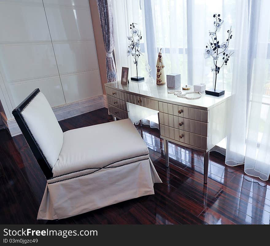 Metal dresser table.big window.white leather chair.wooden floor.pearl necklace. Metal dresser table.big window.white leather chair.wooden floor.pearl necklace.