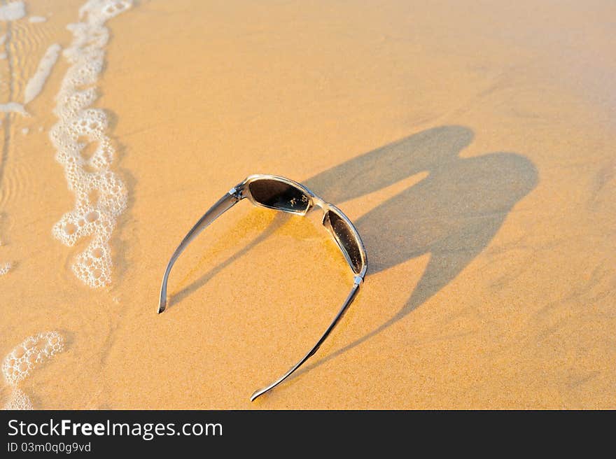 Sun glasses on the sandy sea shore