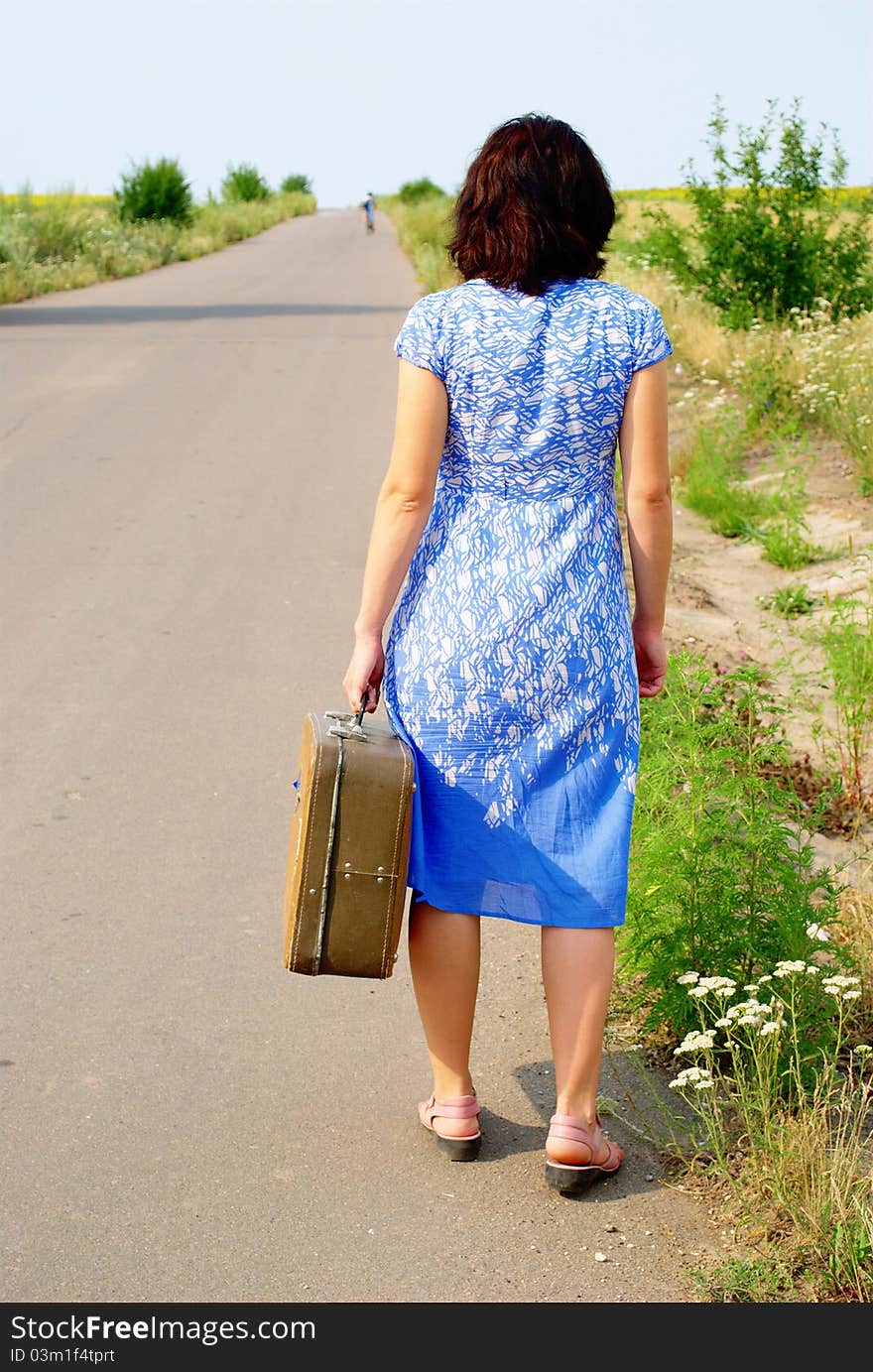 Young girl on the road with a suitcase