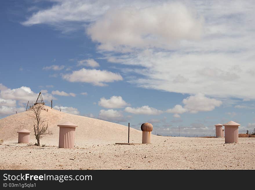 Underground town in desert in cloudy sky