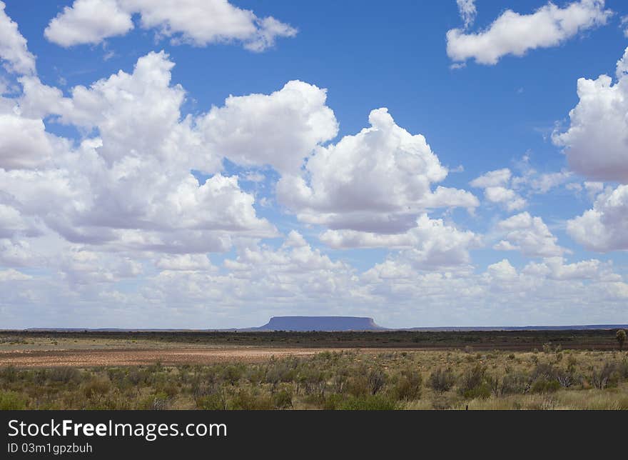 Cloudy sky up to lonely rock in desert