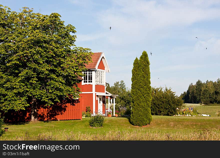 Red cottage in the country in summertime. Red cottage in the country in summertime.