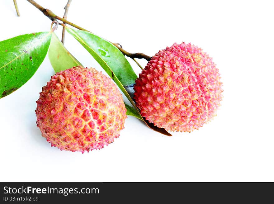 Fresh red lichi fruits with green leaves on a white background