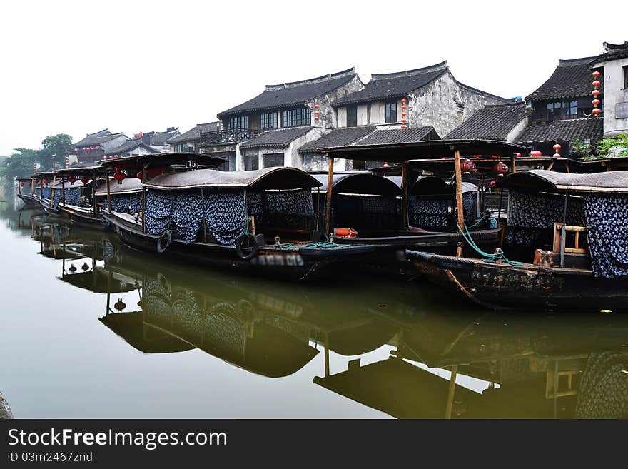 Old water town , some old boats on river， which  reflecte on the river in early morning. Old water town , some old boats on river， which  reflecte on the river in early morning