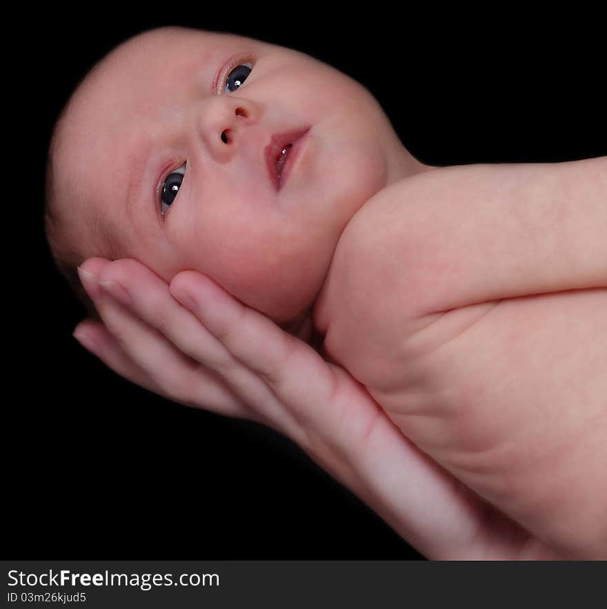 Woman holding alert newborn with one hand. isolated on black. Woman holding alert newborn with one hand. isolated on black