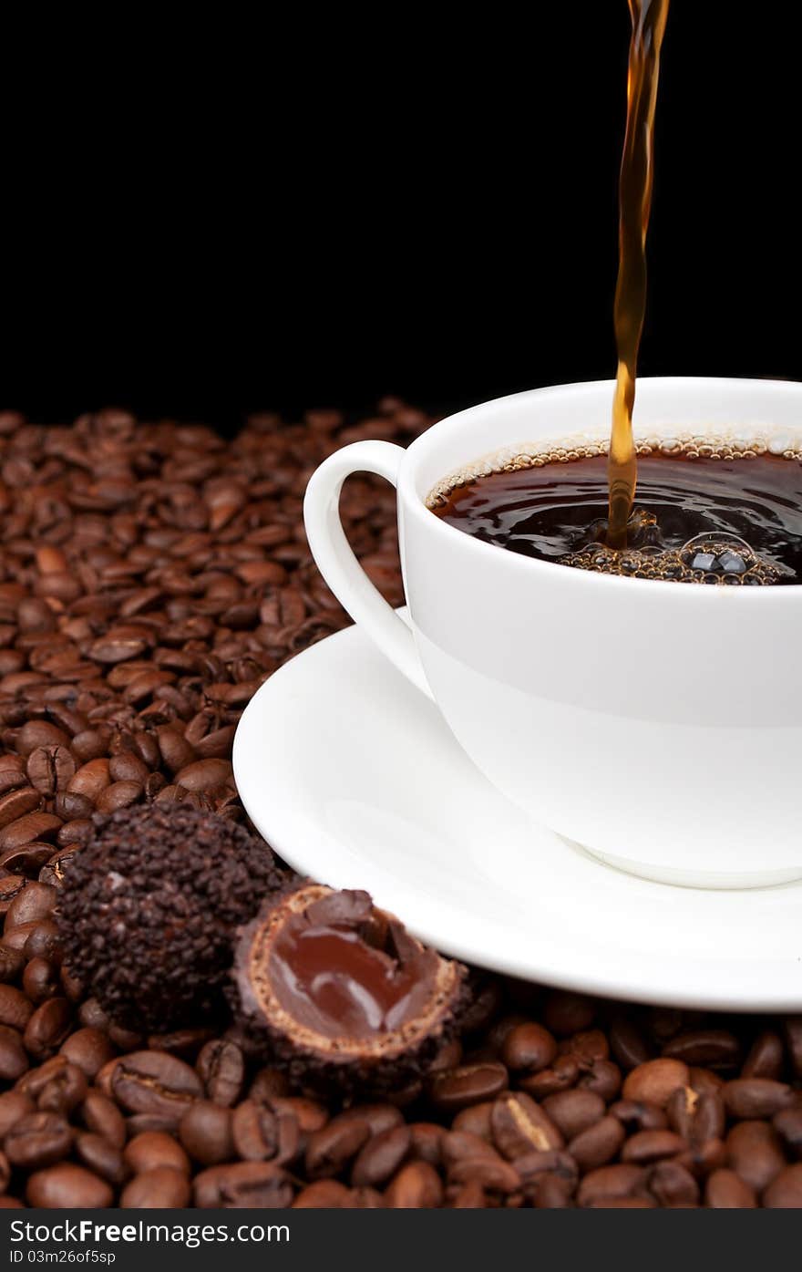 White cup with coffee and coffee beans on a black background. White cup with coffee and coffee beans on a black background