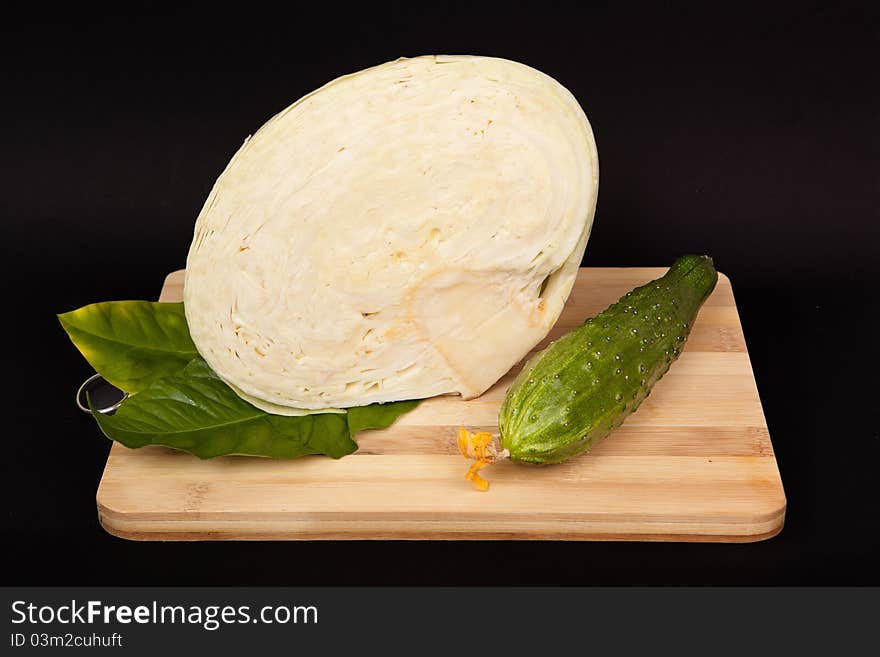 Cabbage and cucumber on wooden table prepared for use