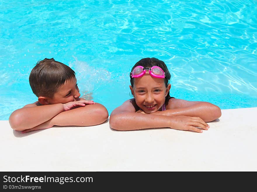 Girl and boy relaxing near  swimming pool