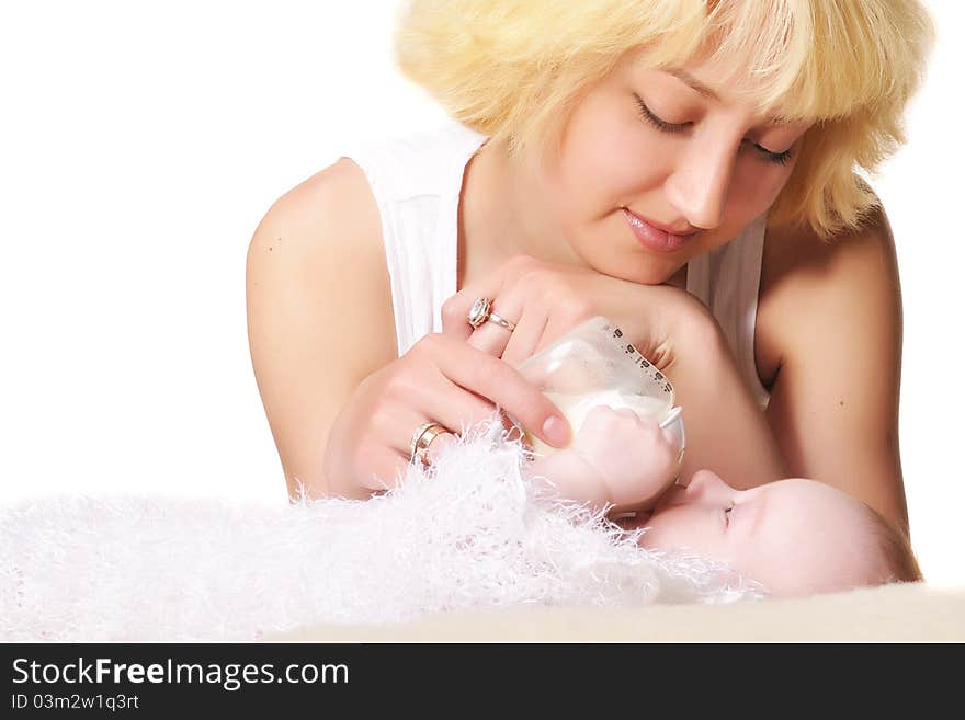 A young mother feeds her baby by the small bottle