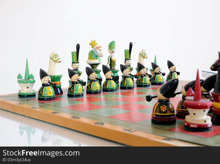 Colorful chess pieces on wood board