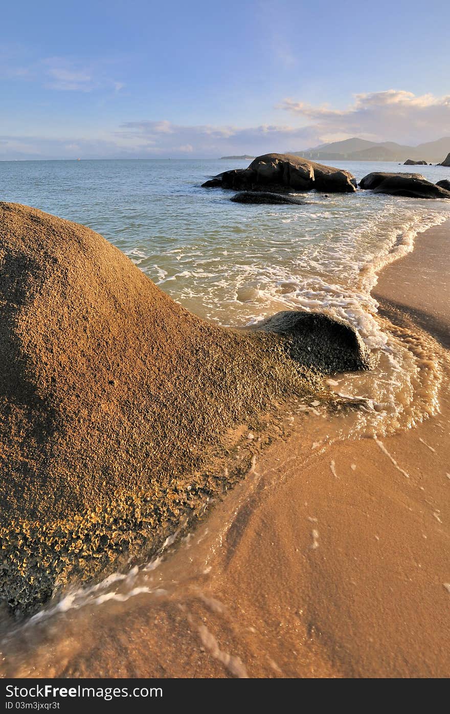 Rocky on sea beach coast under sunset warm lighting, shown as featured light, color and physiognomy. Rocky on sea beach coast under sunset warm lighting, shown as featured light, color and physiognomy.