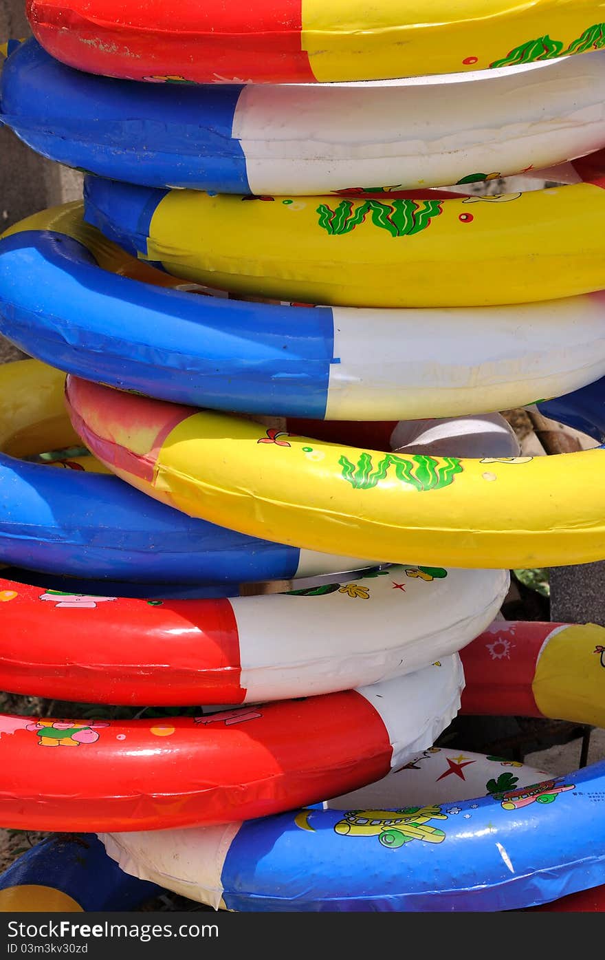 Colorful life buoy in stack under sun lighting, shown as sea beach holidy things and beautiful color and ring shape. Colorful life buoy in stack under sun lighting, shown as sea beach holidy things and beautiful color and ring shape.