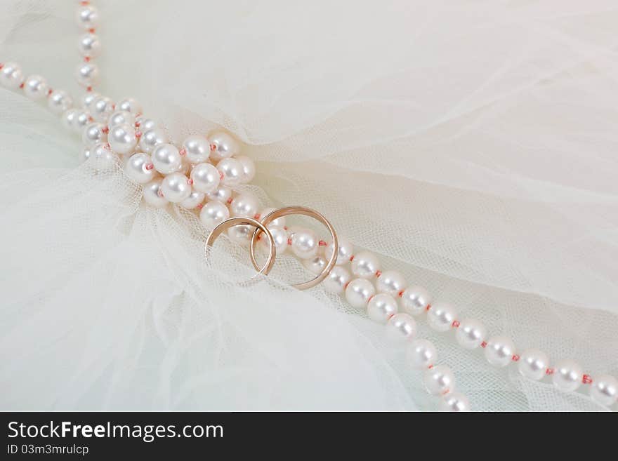 Wedding rings and a pearl necklace