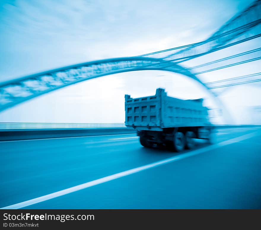 Road through the bridge with blue sky background of a city.