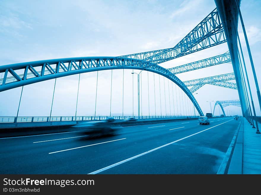 Road through the bridge with blue sky background of a city.