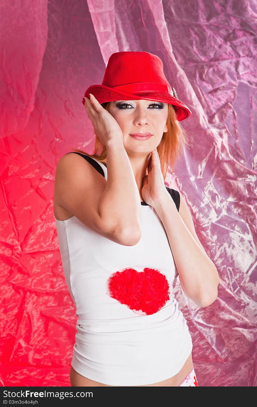 Pretty woman in red hat in studio