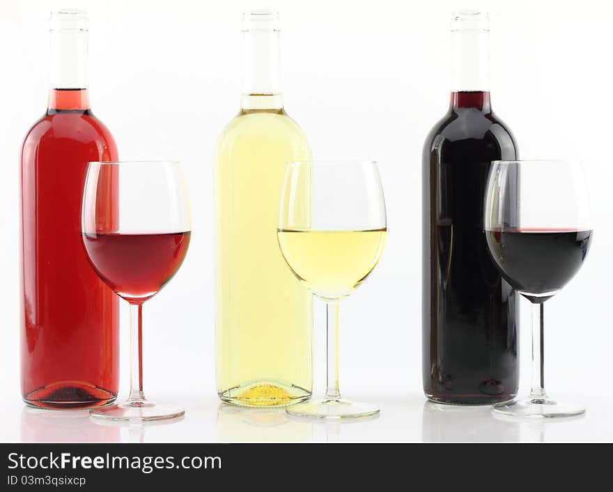 Three colors of wine in bottles and glasses