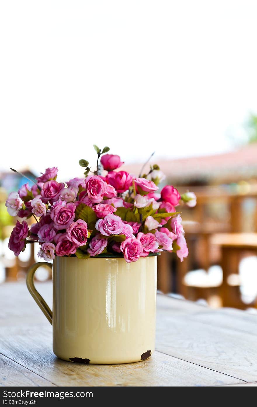 Artificial pink roses in the old metal vase. Artificial pink roses in the old metal vase