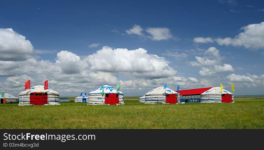 Red Yurts on the grassland under blue sky and white clouds in the north of China, beautiful.