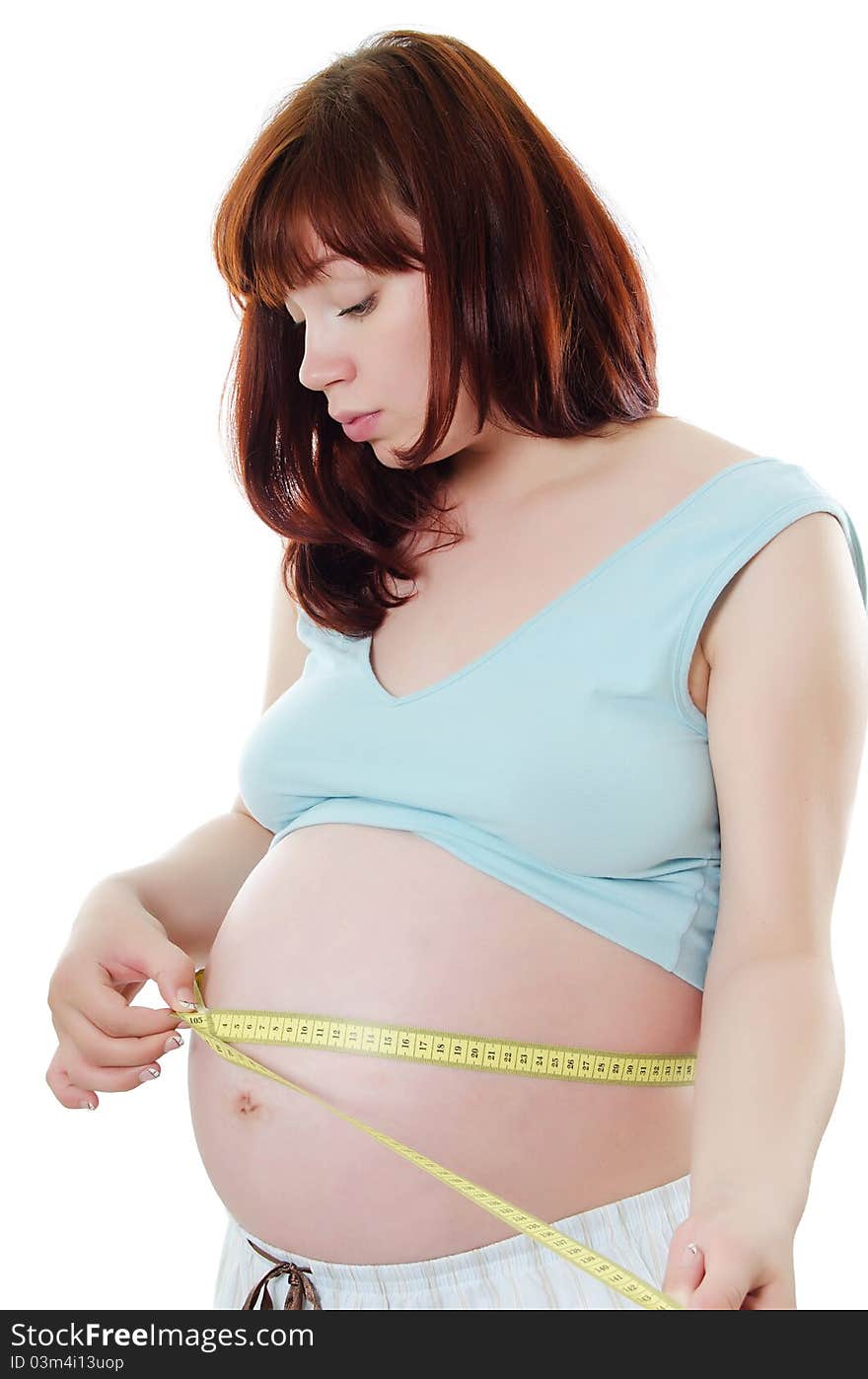 The pregnant woman with a measuring tape on white