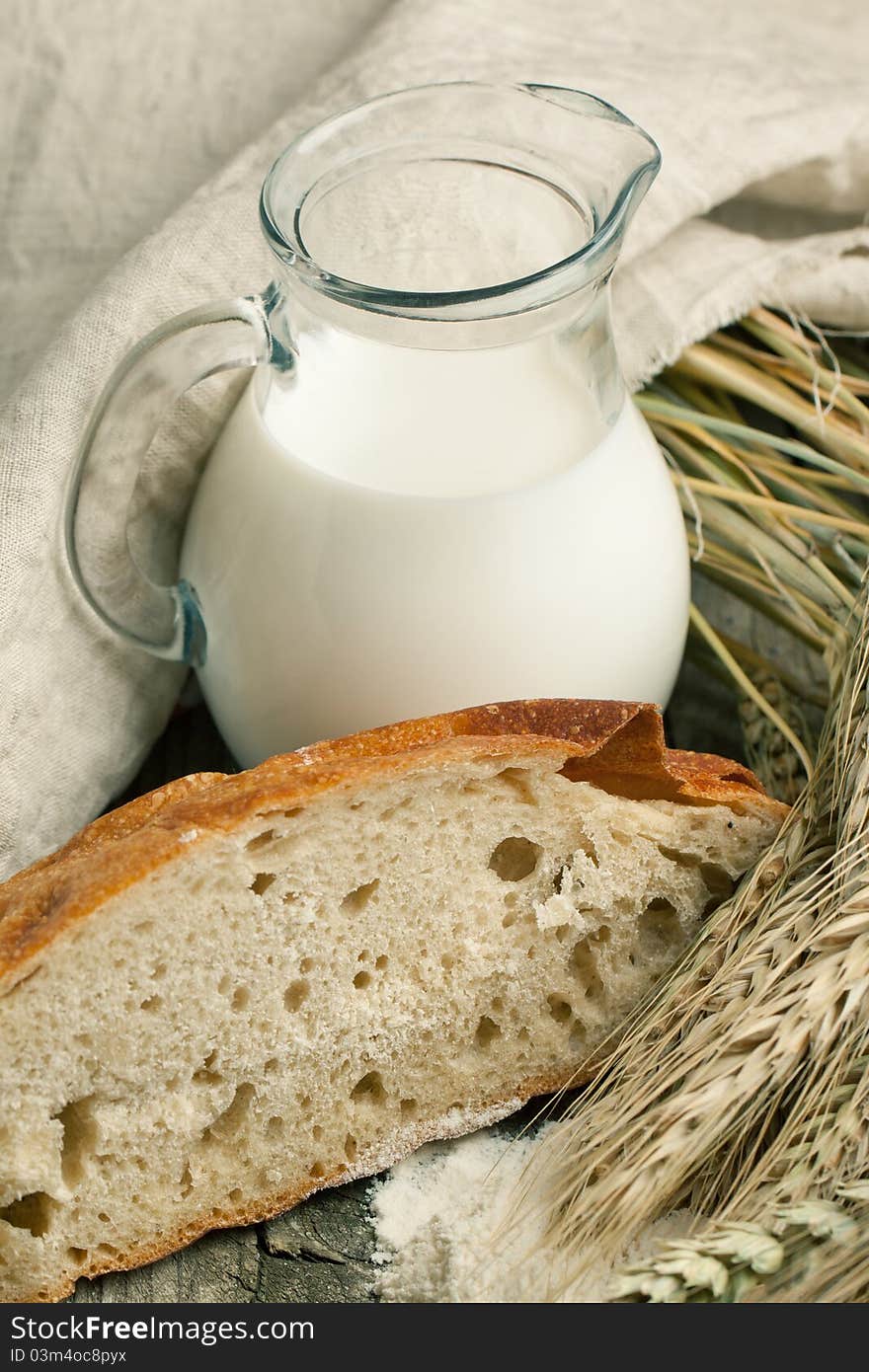 Piece of bread with jug of milk and spikes of rye. Piece of bread with jug of milk and spikes of rye