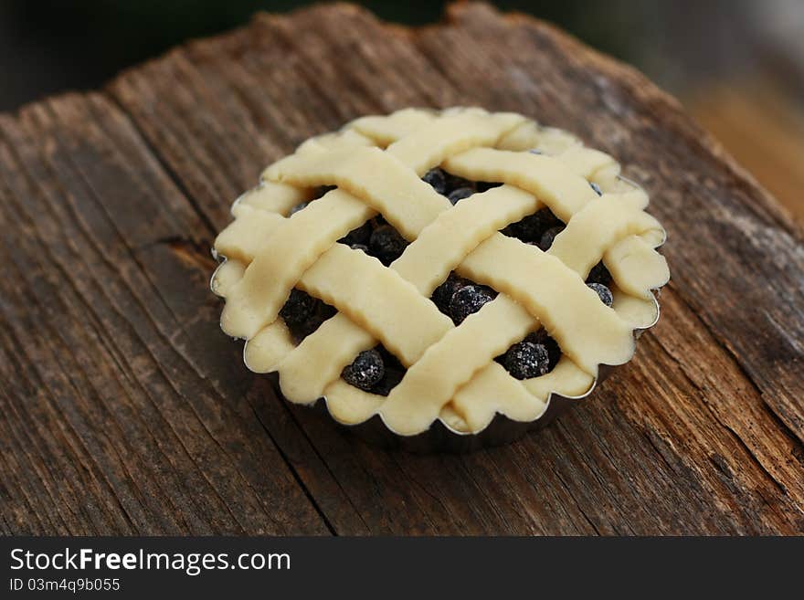 Fresh blueberry tart with lattice top on a wood