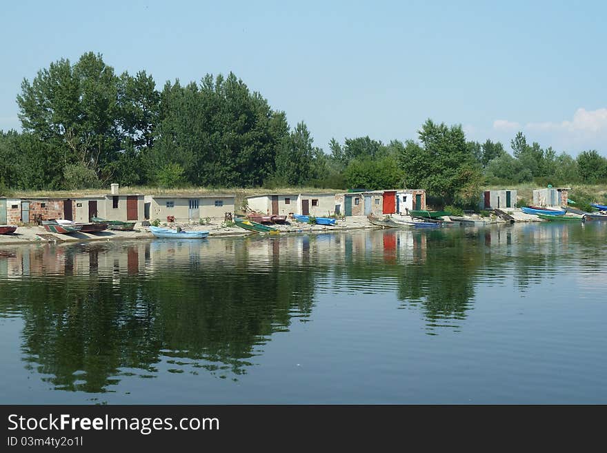 They keep and store the kayaks and canoes in these buildings. The river is Danube, in Serbia. They keep and store the kayaks and canoes in these buildings. The river is Danube, in Serbia