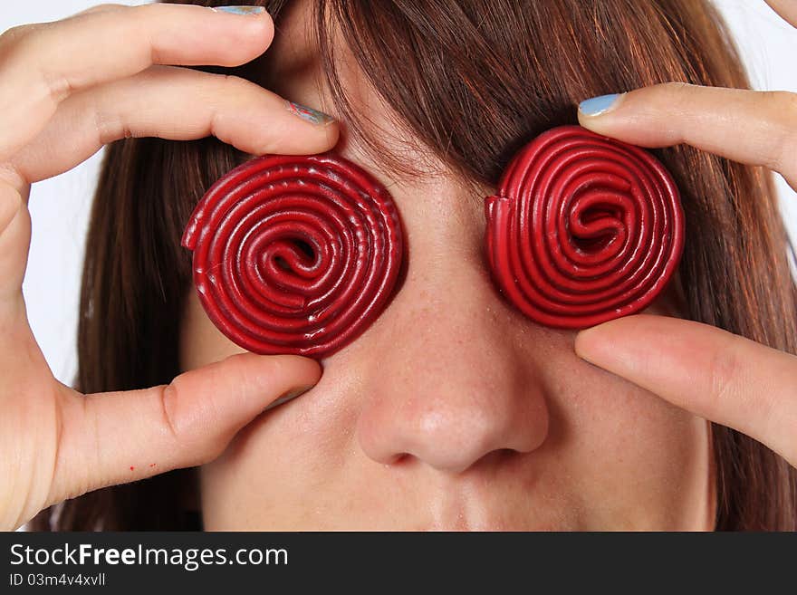 Girl with red candy sweets on her eyes. Girl with red candy sweets on her eyes