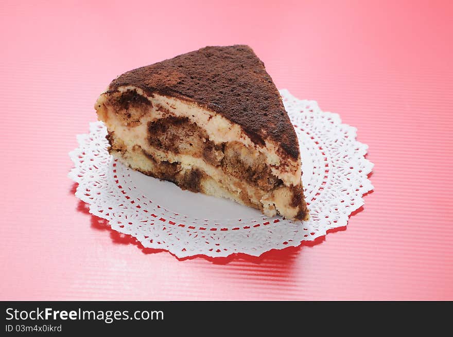 Slice piece of Tiramisu with white paper on red background. Slice piece of Tiramisu with white paper on red background.