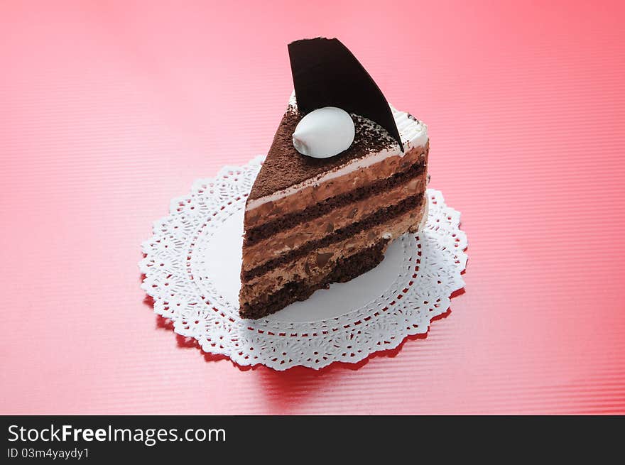 Chocolate shortcake with round white paper on red background. Chocolate shortcake with round white paper on red background