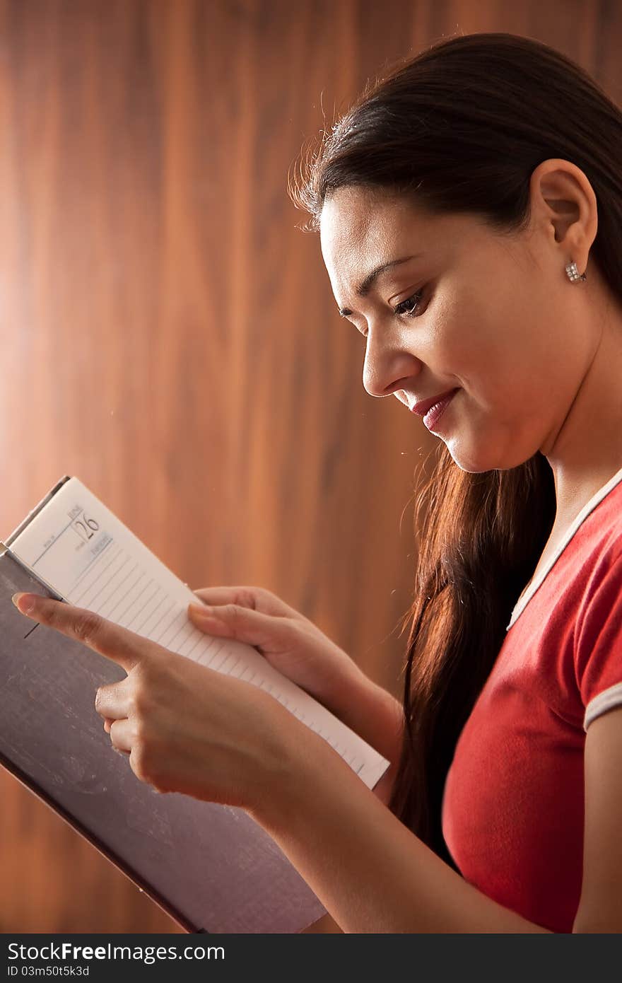 Pretty indian woman reading her diary. Pretty indian woman reading her diary