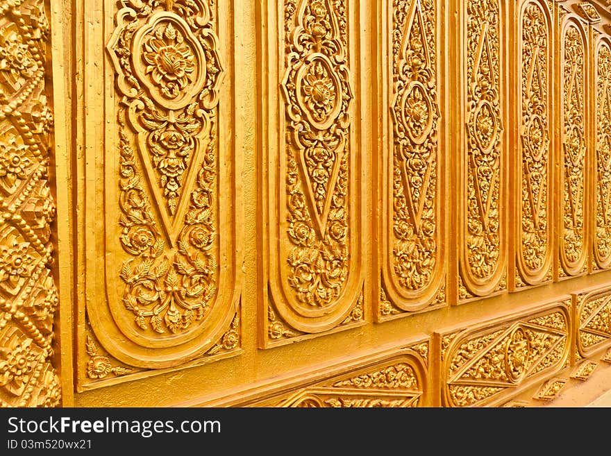 Golden Thai pattern desing on temple wall close up tilted out. Golden Thai pattern desing on temple wall close up tilted out