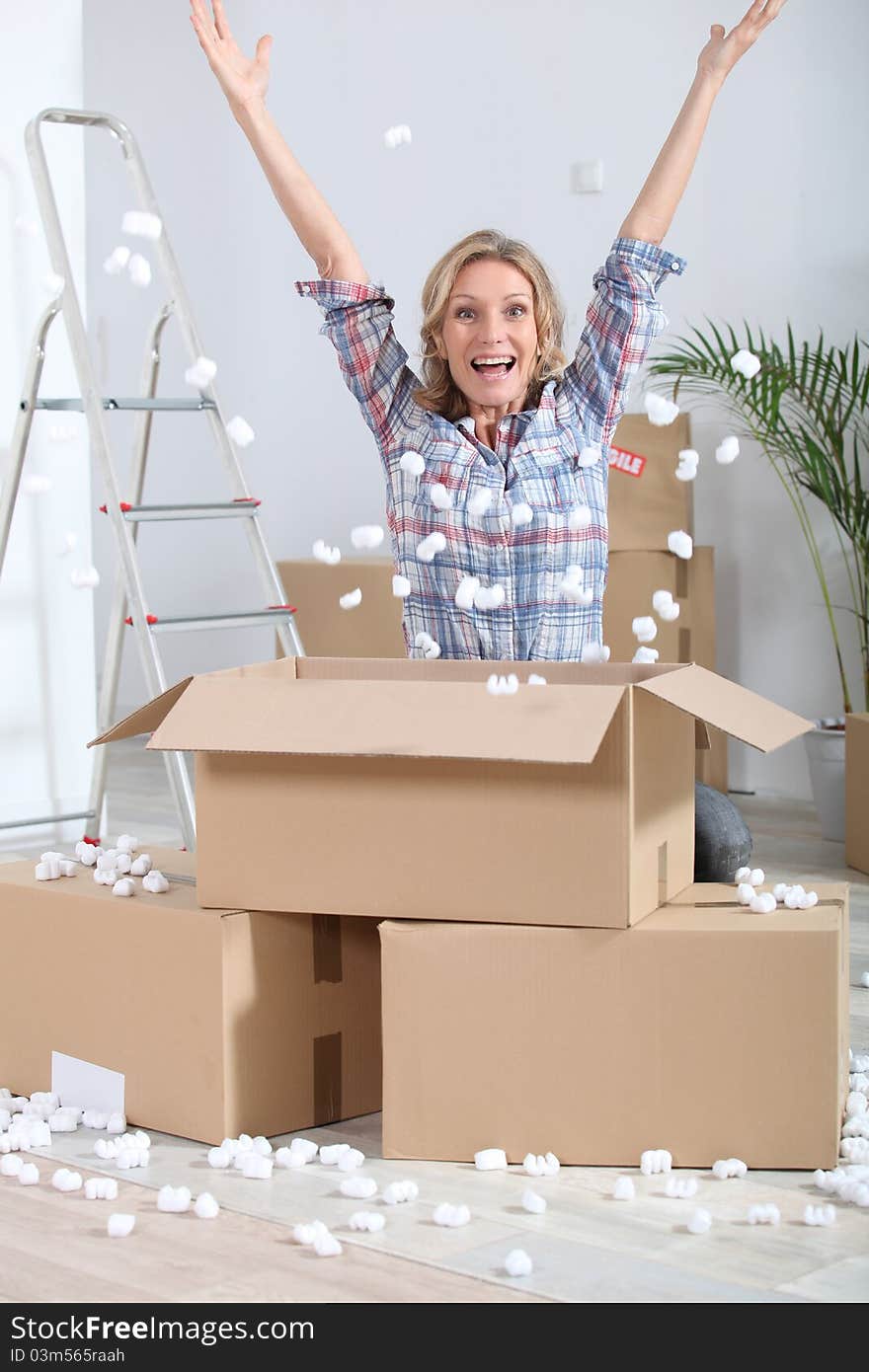 Woman crouching in front of stacked cardboard boxes. Woman crouching in front of stacked cardboard boxes