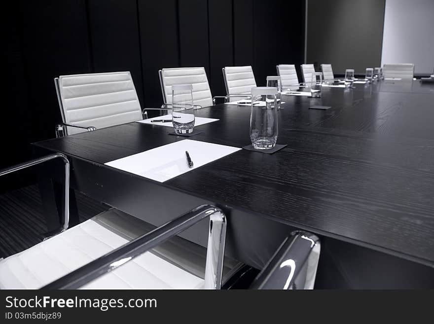 Meeting room interior with table, raw of chairs and block-notes,decorated in sepia and white tones