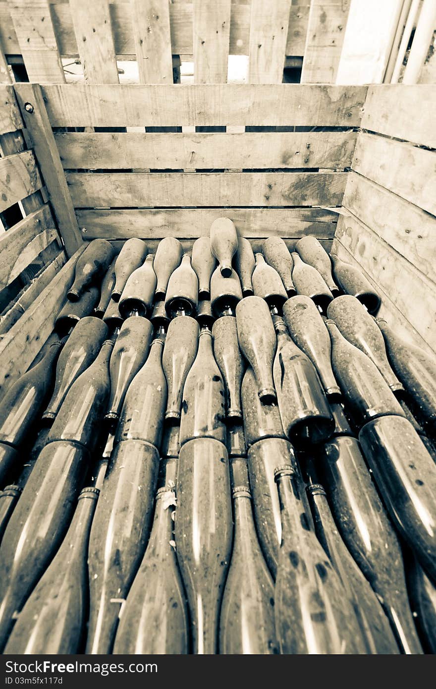 Wide angle shot of the wooden box with stacked old bottles of wine. Wide angle shot of the wooden box with stacked old bottles of wine