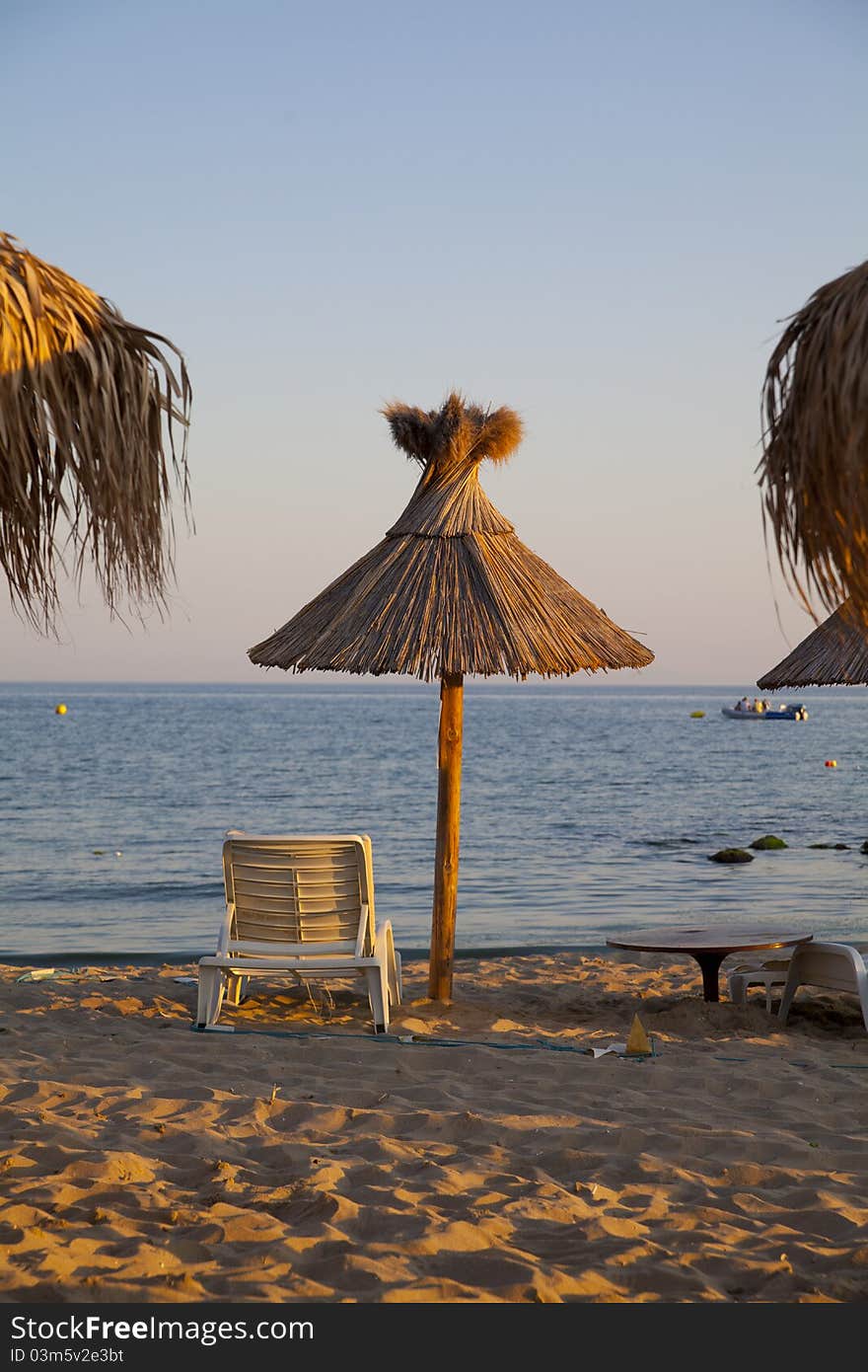 Beach with palms umbrella and chairs