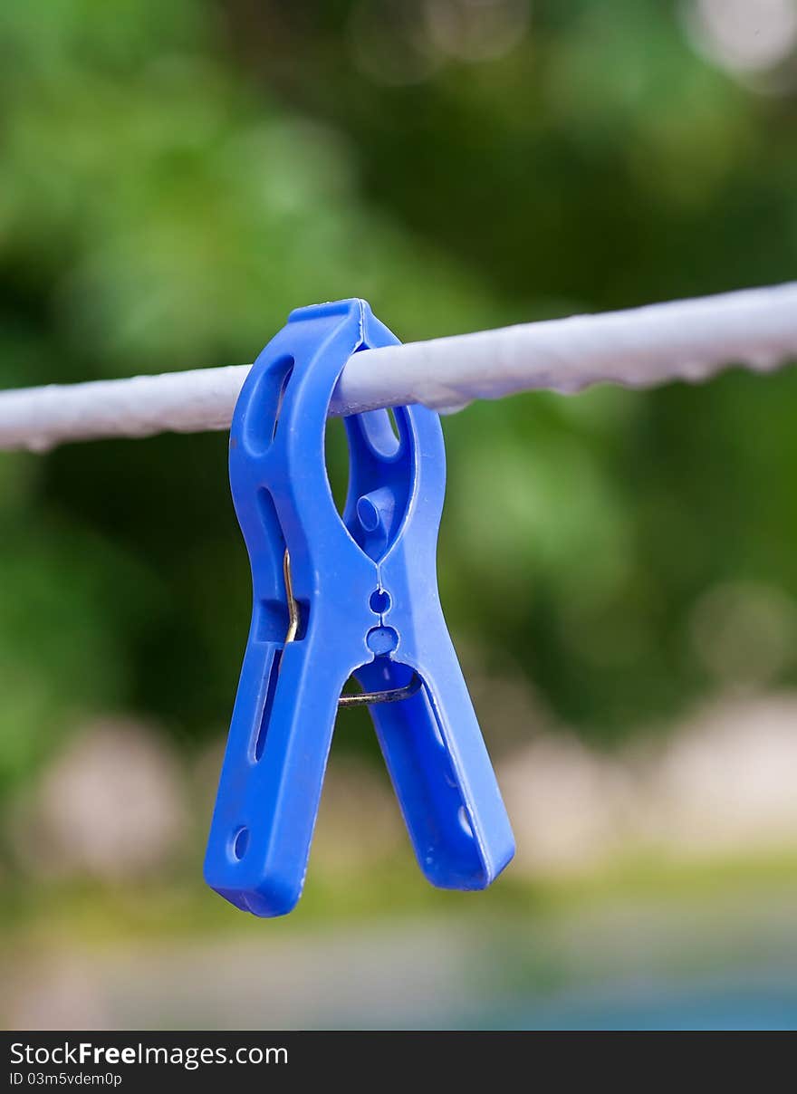 Blue clothespin on the line, in the nature