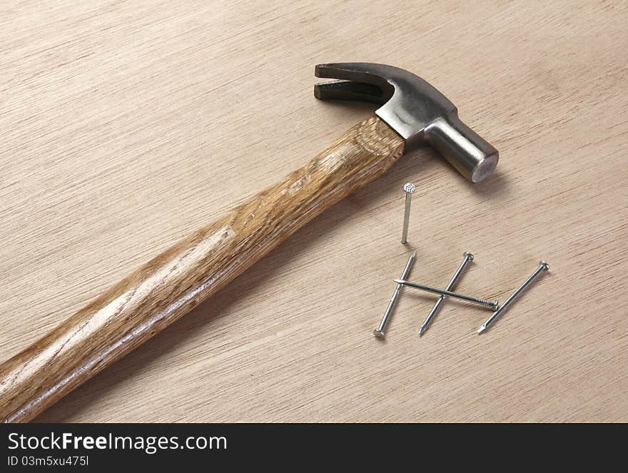 Vintage hammer with nails on wooden