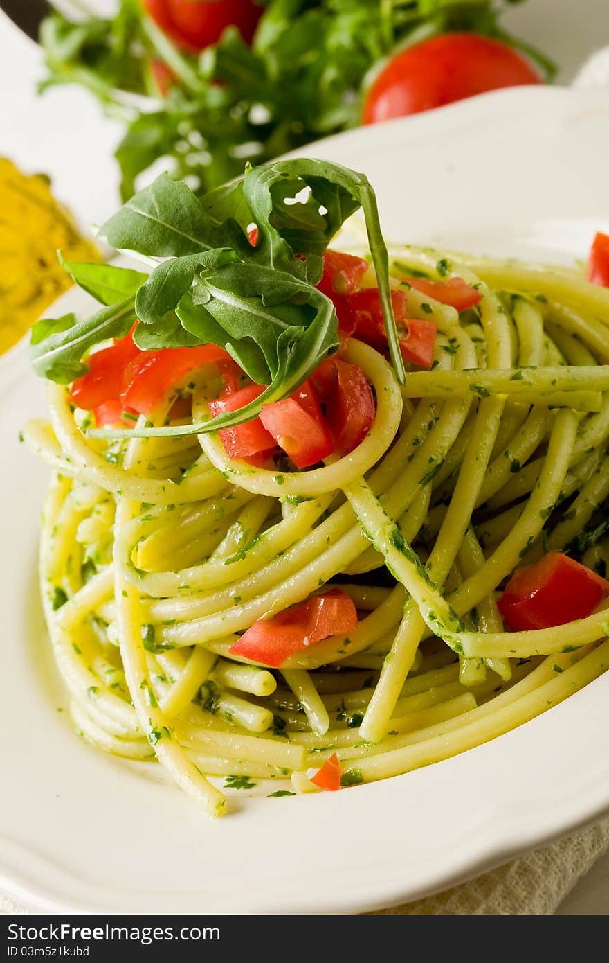 Photo of delicious pasta with arugula pesto and cherry tomatoes