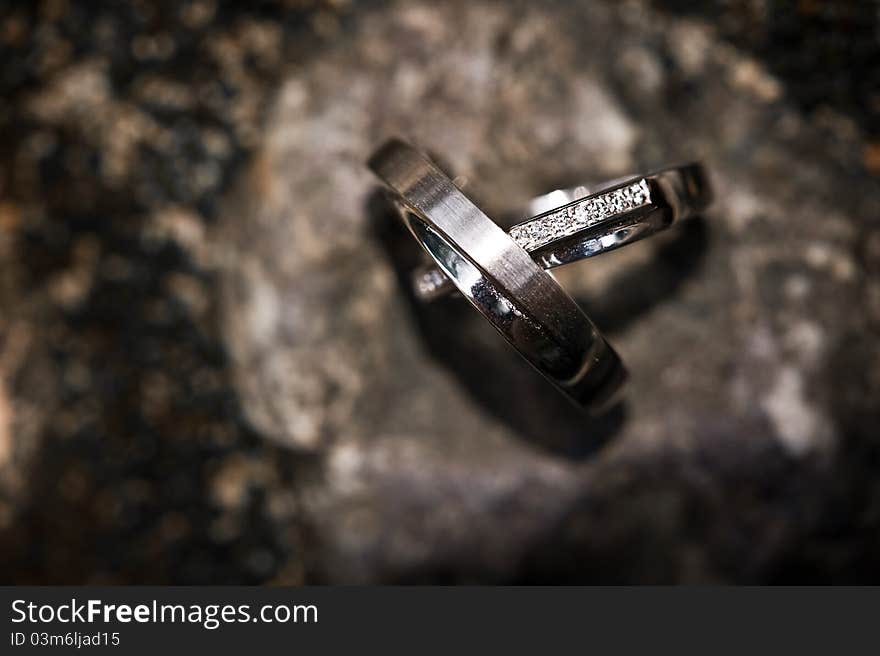 Wedding rings on a rocky background