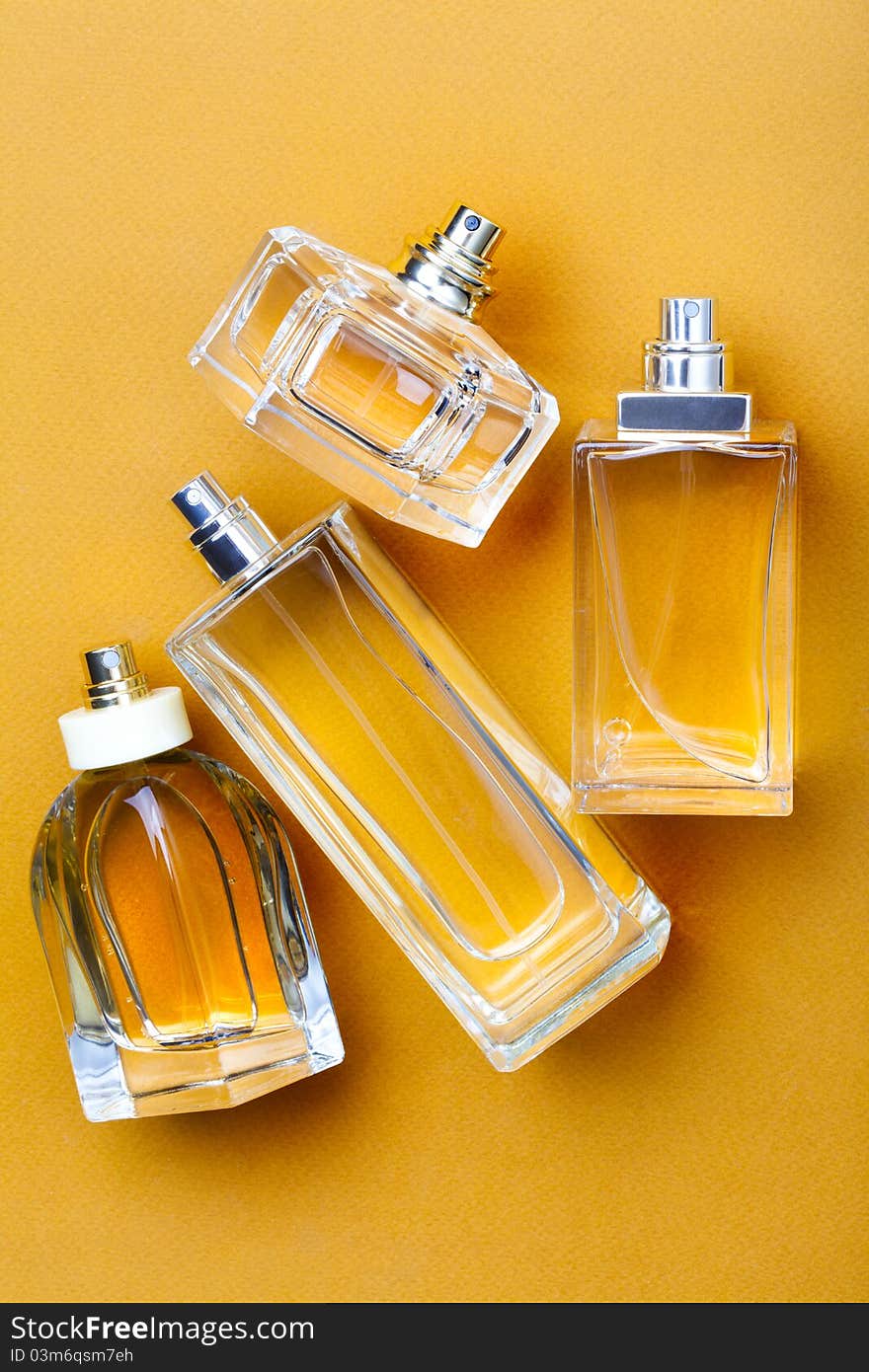 Yellow perfume bottles on yellow background