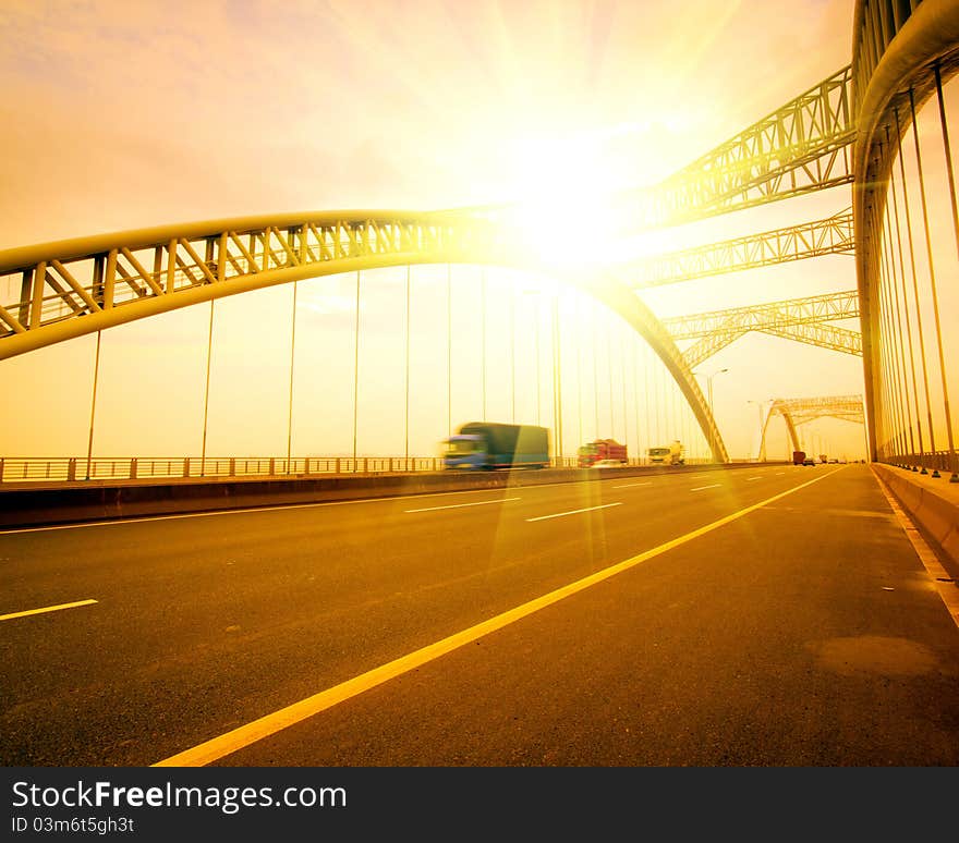 Road through the bridge with blue sky background of a city.