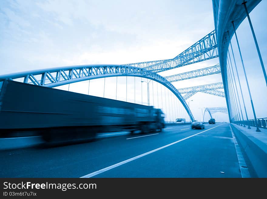 Road through the bridge with blue sky background of a city.