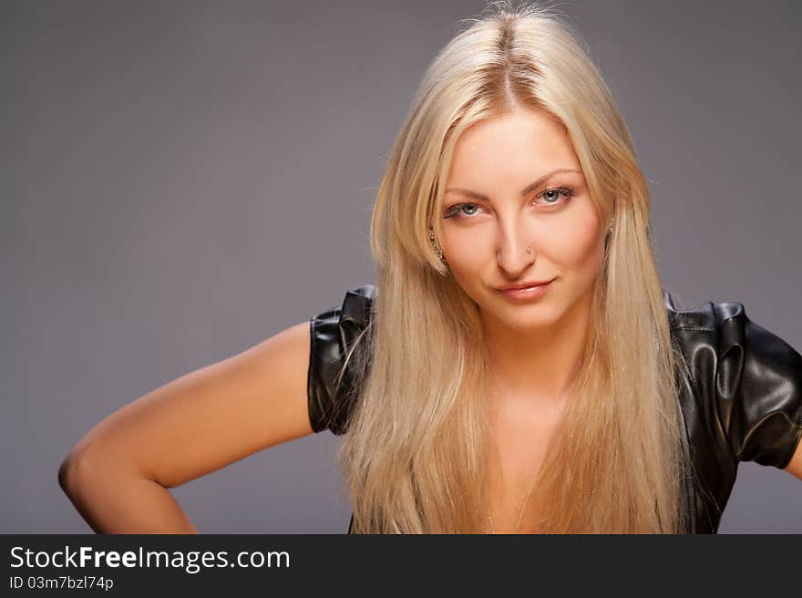 Young woman with beautiful blonde hair on a gray background. Young woman with beautiful blonde hair on a gray background